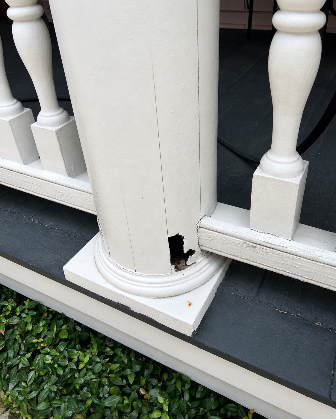 Rot visible at the base of a painted porch column