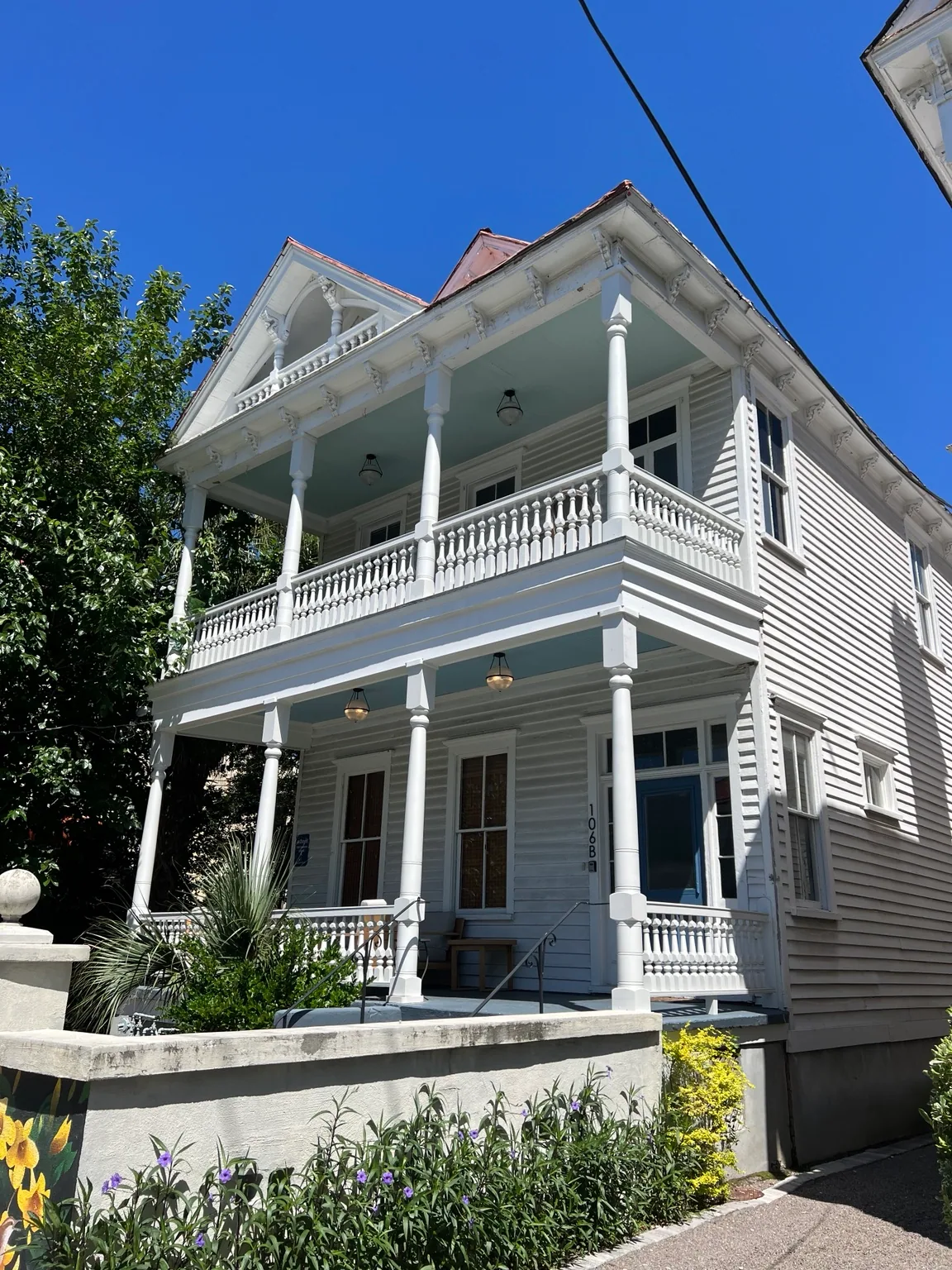 Restored historic Charleston porch with repaired columns and railing